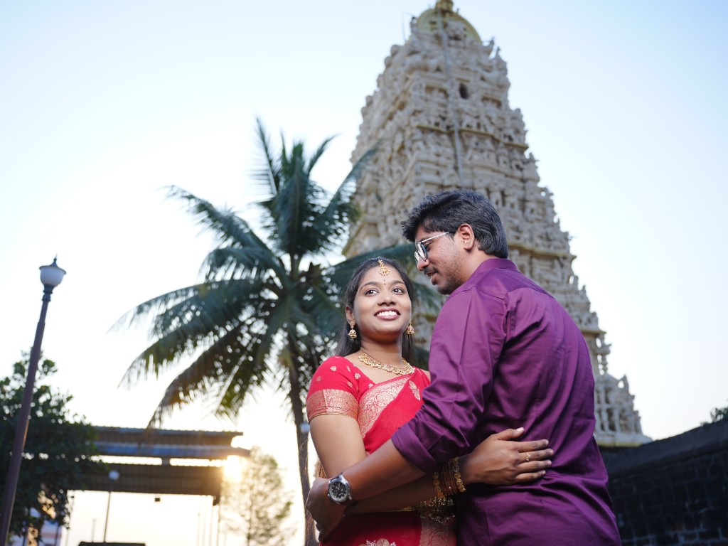 Couple in traditional outfits in front of a temple gopuram