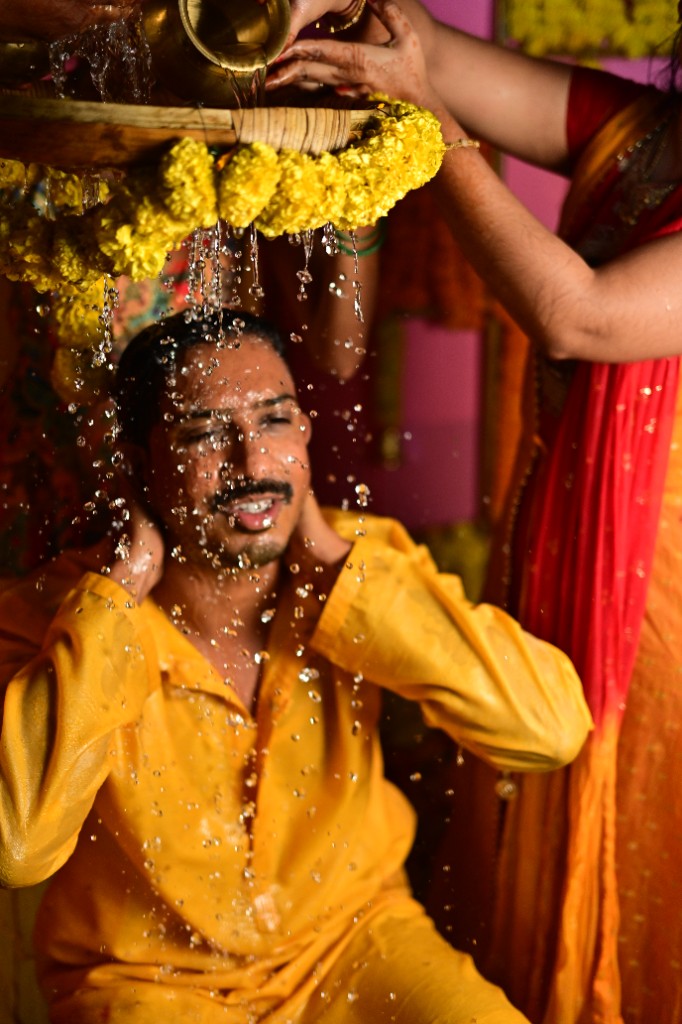 Haldi being applied to the bride's face with a joyful expression