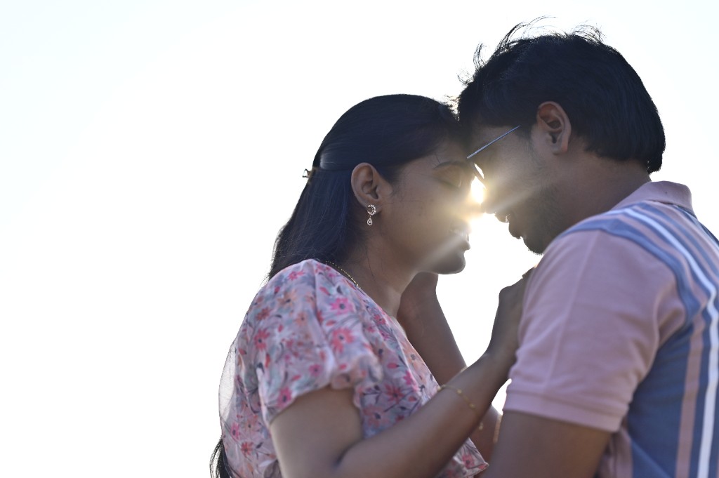Srinu and Sai sharing a quiet moment at the beach with sunset between them